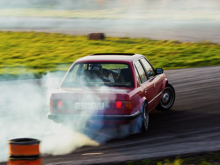 Rinat’s BMW E30 sliding through a corner in tyre smoke.